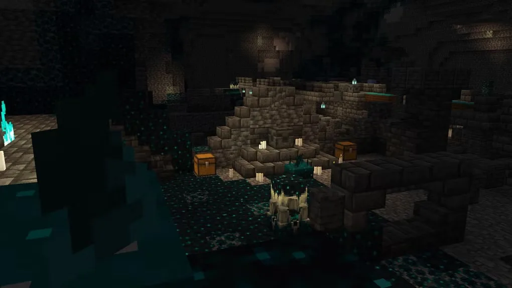 Minecraft in-game cavern with stone ruins, chests, candles and blue-green sculk